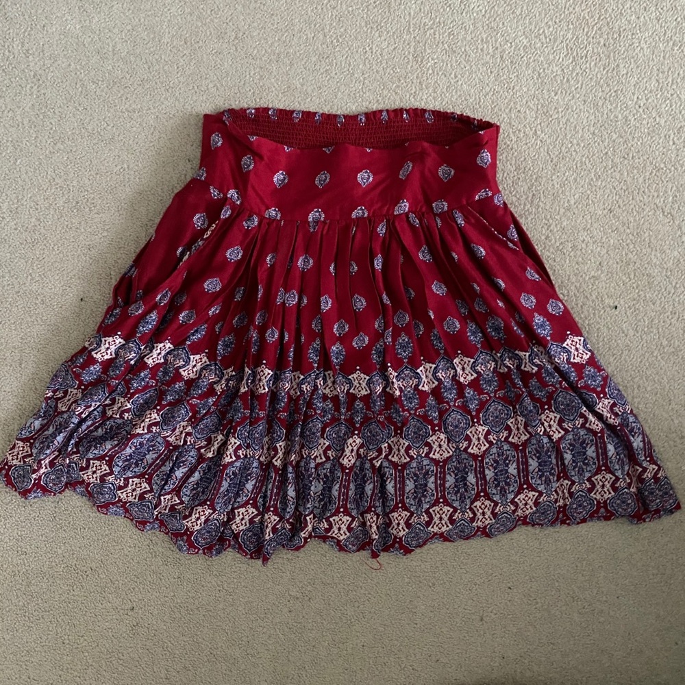 Red patterned pleated skirt.